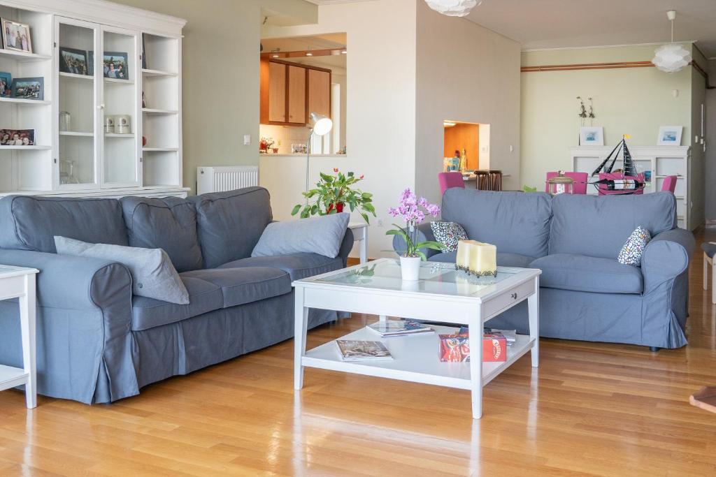 a living room with blue couches and a white table at The Skyward Flats in Nea Smyrni