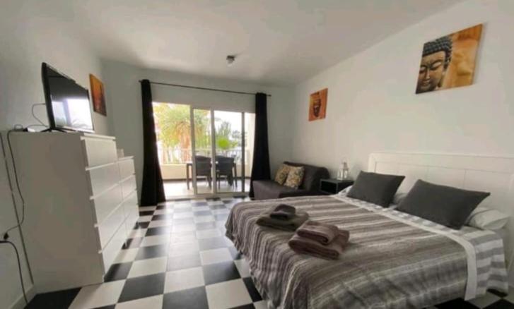 1 dormitorio con 1 cama y suelo a cuadros en Suri Costa Teguise, en Costa Teguise