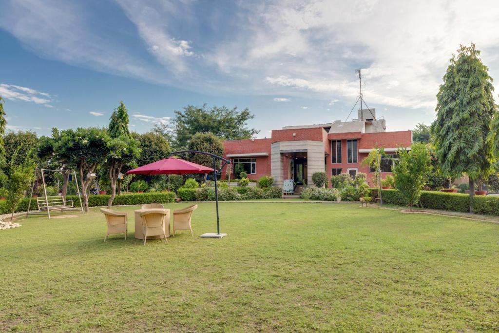 a garden with a table and chairs in front of a building at Avanti Retreat- Farm Stay in Dera Māndi