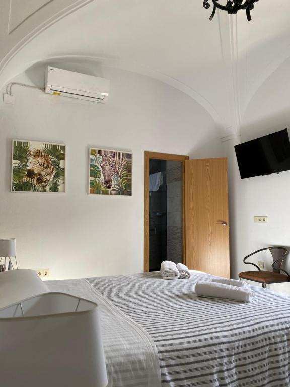 una camera bianca con un letto con due asciugamani di Complejo Rural Rincón del Paraíso a Valencia del Mombuey