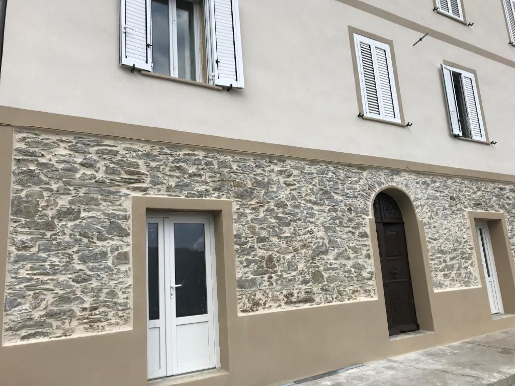 une façade en pierre d'un bâtiment avec fenêtres dans l'établissement Maison de maître Ortiporiu, à Ortiporio