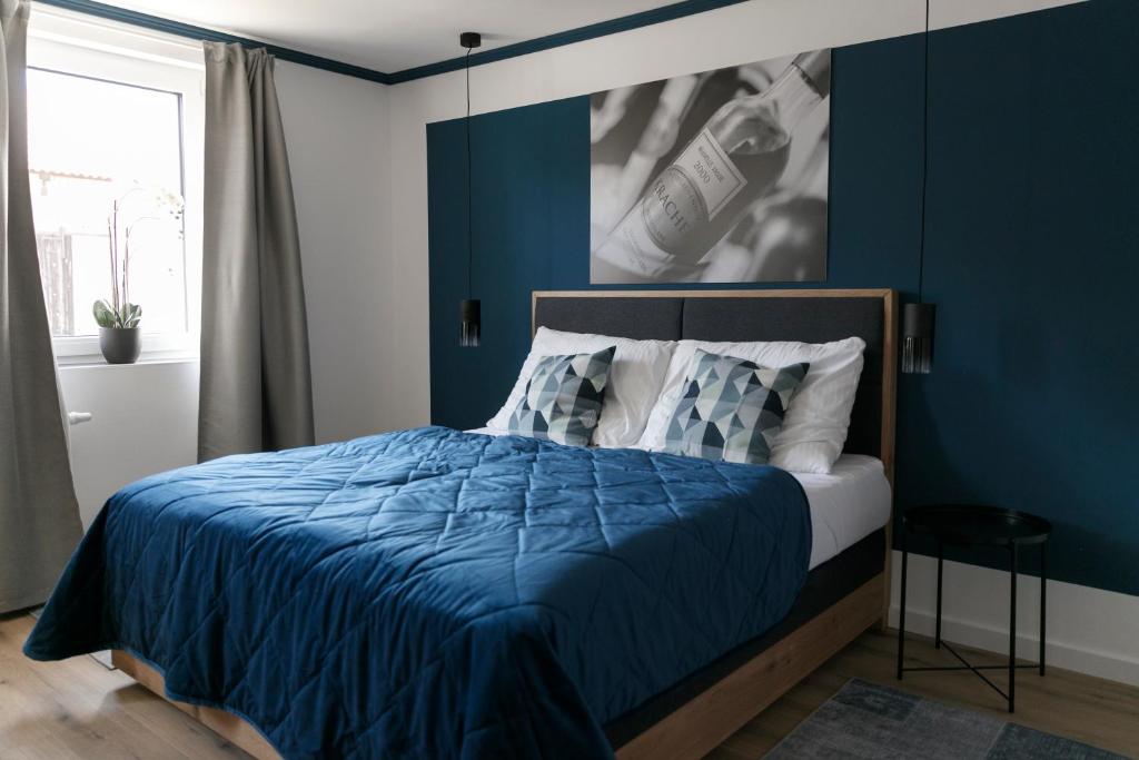 um quarto com paredes azuis e uma cama com lençóis azuis em KRACHER Ferienhaus Landhaus No 1 em Illmitz