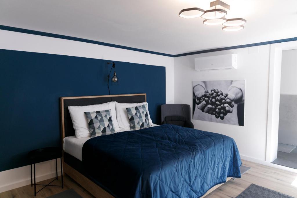 um quarto com uma cama com uma parede azul em KRACHER Landhaus No. 2 em Illmitz