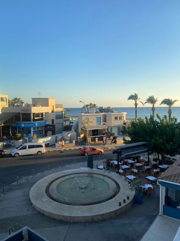 Blick auf eine Stadt mit einem Brunnen und das Meer in der Unterkunft Player Sea View apartment in Paphos City