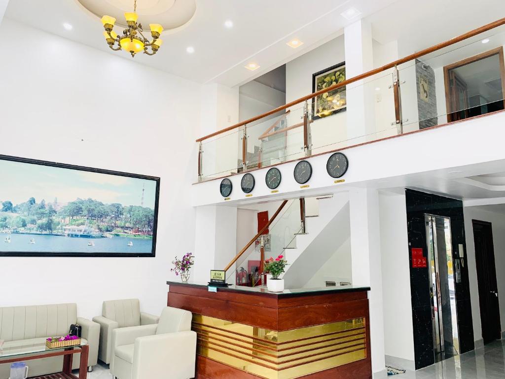 ein Wohnzimmer mit einer Treppe mit Uhren an der Wand in der Unterkunft Khách sạn Nam Ngọc Đà Lạt in Da Lat