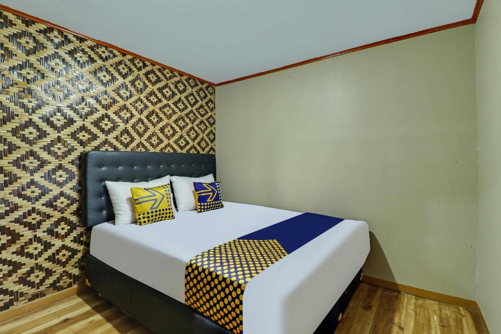 - une chambre avec un lit et des oreillers colorés dans l'établissement OYO Homes 90956 Desa Wisata Guranteng, à Panjalu
