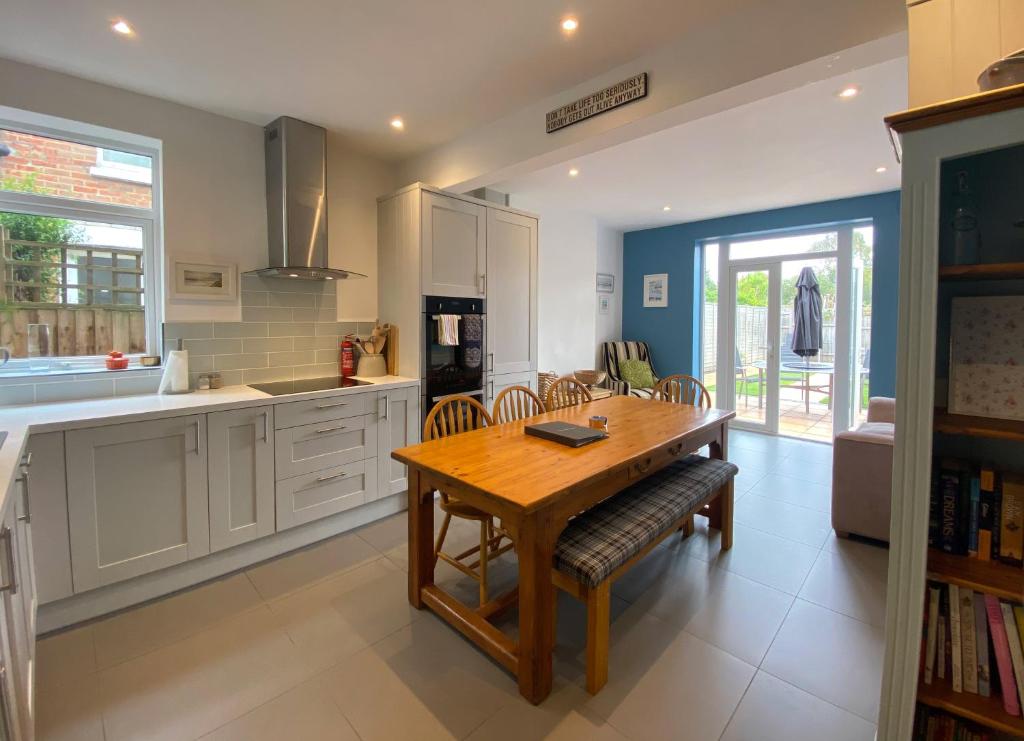 a kitchen with a wooden table and chairs in it at Charming 3 bed house and garden, pet friendly in Bournemouth