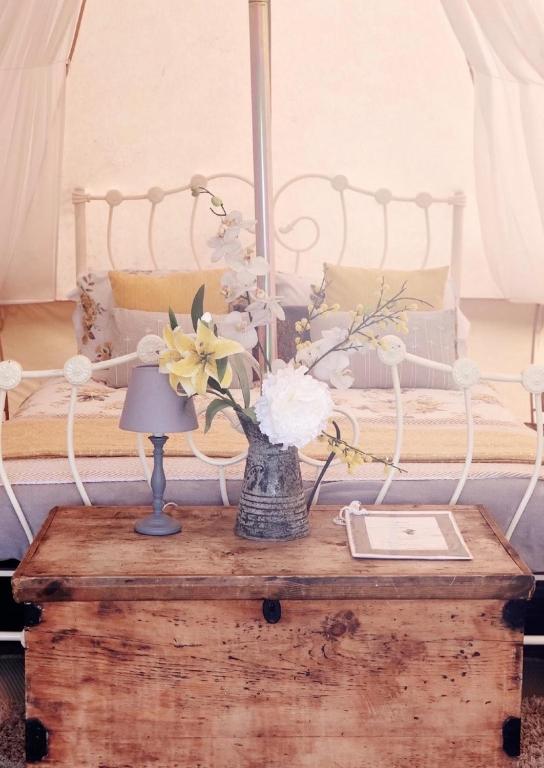 a table with a vase of flowers on top of a bed at Valley Farm Bells in Oxford