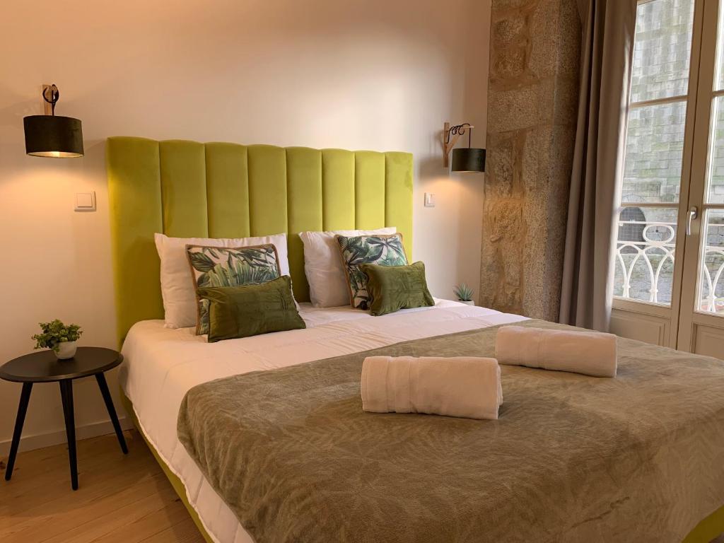 a large bed with a green headboard in a room at Lost Inn Porto Hostel in Porto