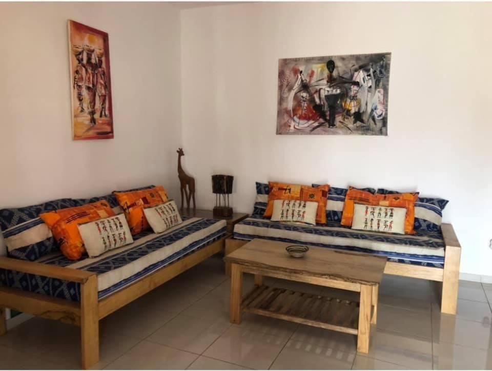 uma sala de estar com 2 camas e uma mesa de centro em La Maison Aziz - Somone / Sénégal em Somone