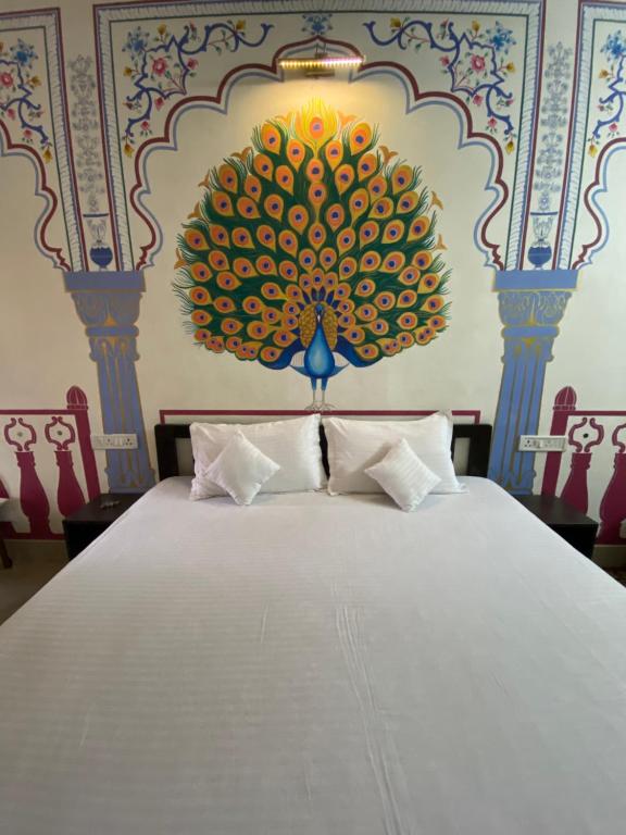 une chambre avec un grand lit avec un tableau au mur dans l'établissement Golden Peacock Heritage Home Stay, à Jaipur