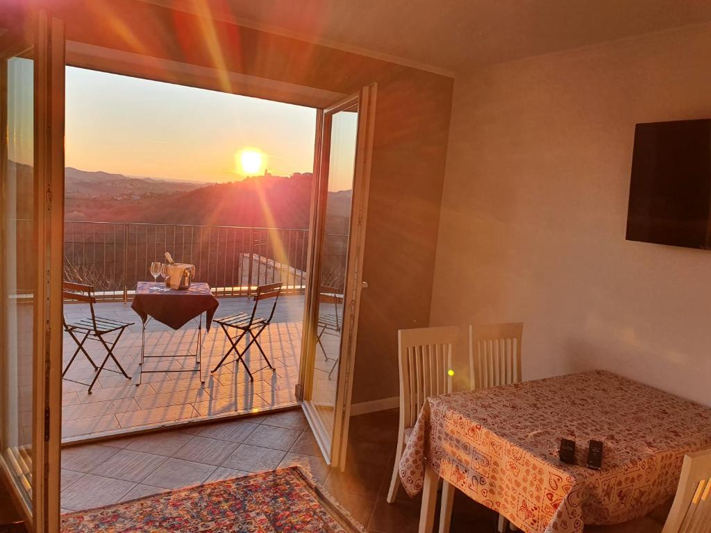 Cette chambre dispose d'une table et d'un balcon avec vue sur le coucher du soleil. dans l'établissement Apartmaji Aucin - Brda, à Kojsko