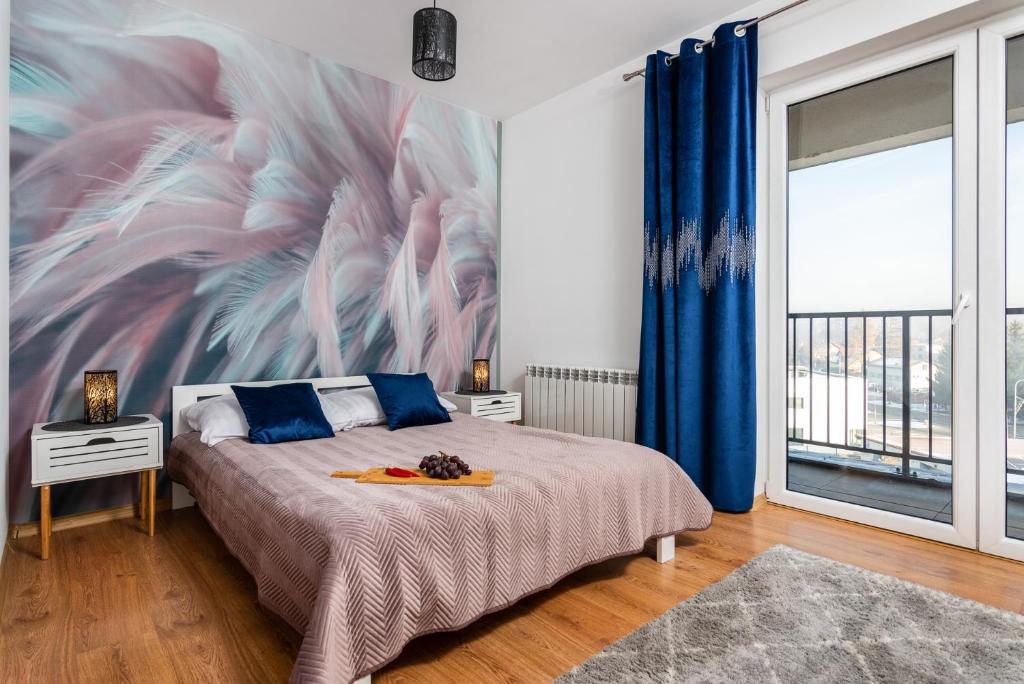 a bedroom with a bed with a painting on the wall at Apartamenty Niko in Zator