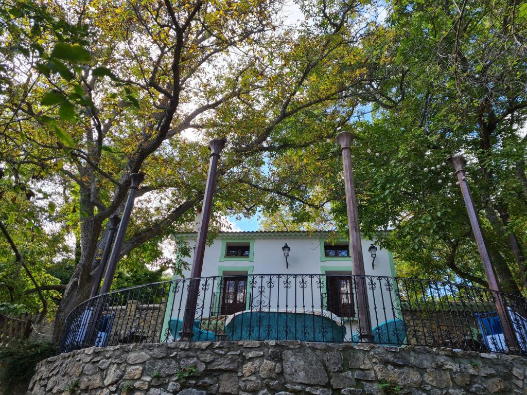 a house behind a stone wall with a fence at Molino Sauco - Hammam in Puebla de Don Fadrique