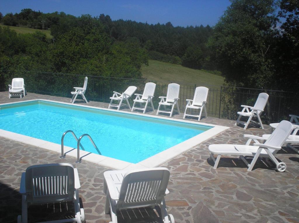 a group of chairs and a swimming pool at Casa vacanza montecapino in Chiusdino