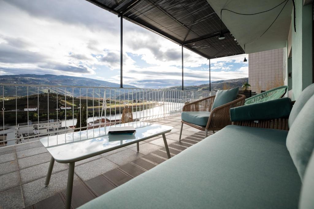 a balcony with a table and chairs and a view at Green House - Douro in Peso da Régua