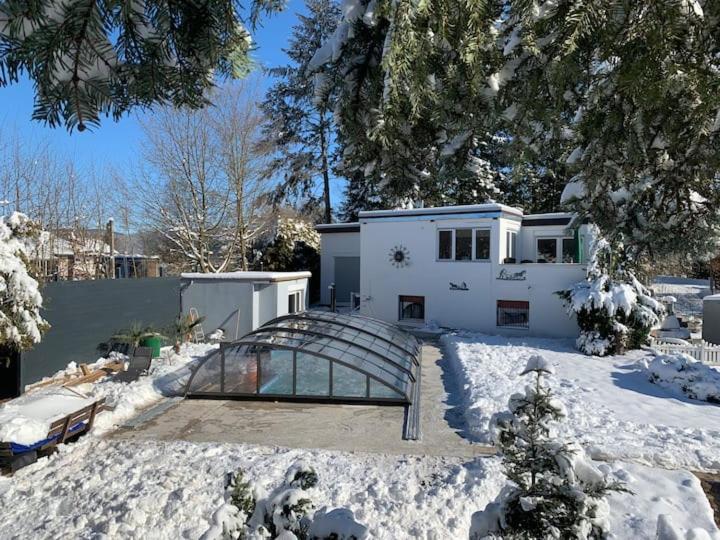 una casa blanca con techo de cristal en la nieve en Ferienhaus am Edersee, en Scheid