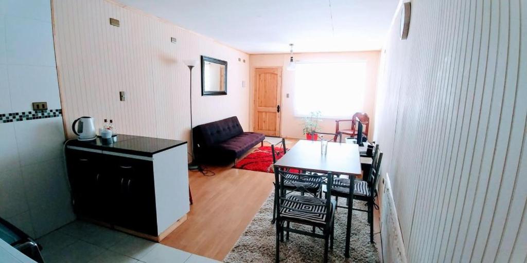a kitchen and living room with a table and chairs at Furnished Apartment Cabaas del Profe in Puerto Montt