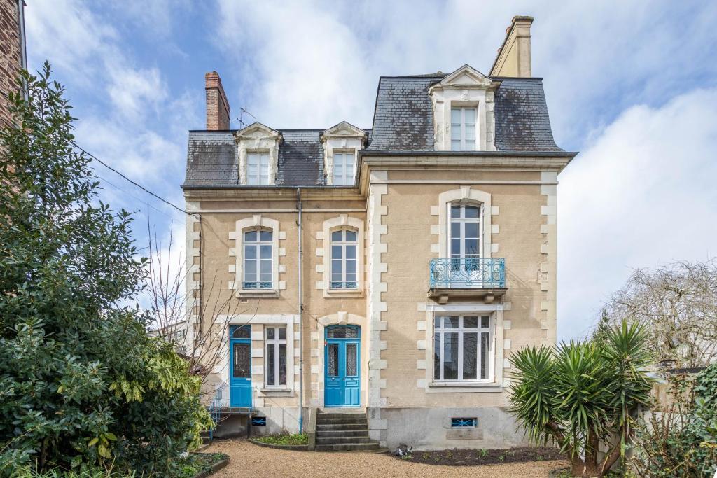 an old house with a blue door and windows at LE SEIZE - Appartement spacieux au cœur d'un quartier calme de Rennes in Rennes