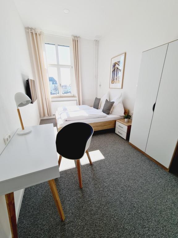 1 dormitorio con cama, escritorio y silla en Best Boarding House, en Hanau am Main