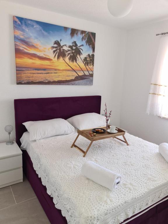 a bedroom with a bed with a table on it at Apartments Lujić in Crikvenica