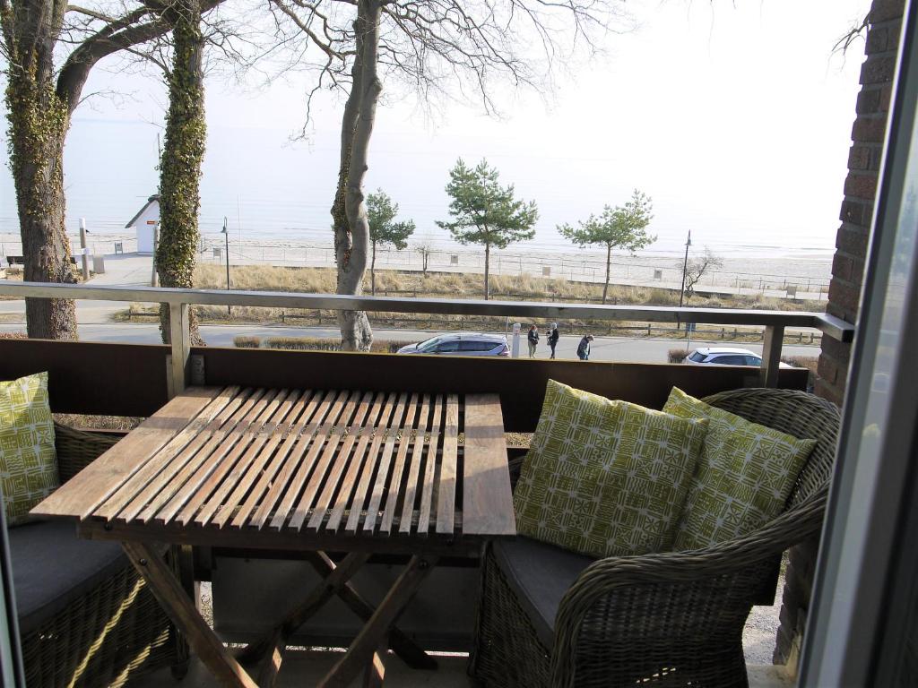 drewniany stół i krzesła na balkonie z widokiem w obiekcie Sea View Lodge w mieście Scharbeutz