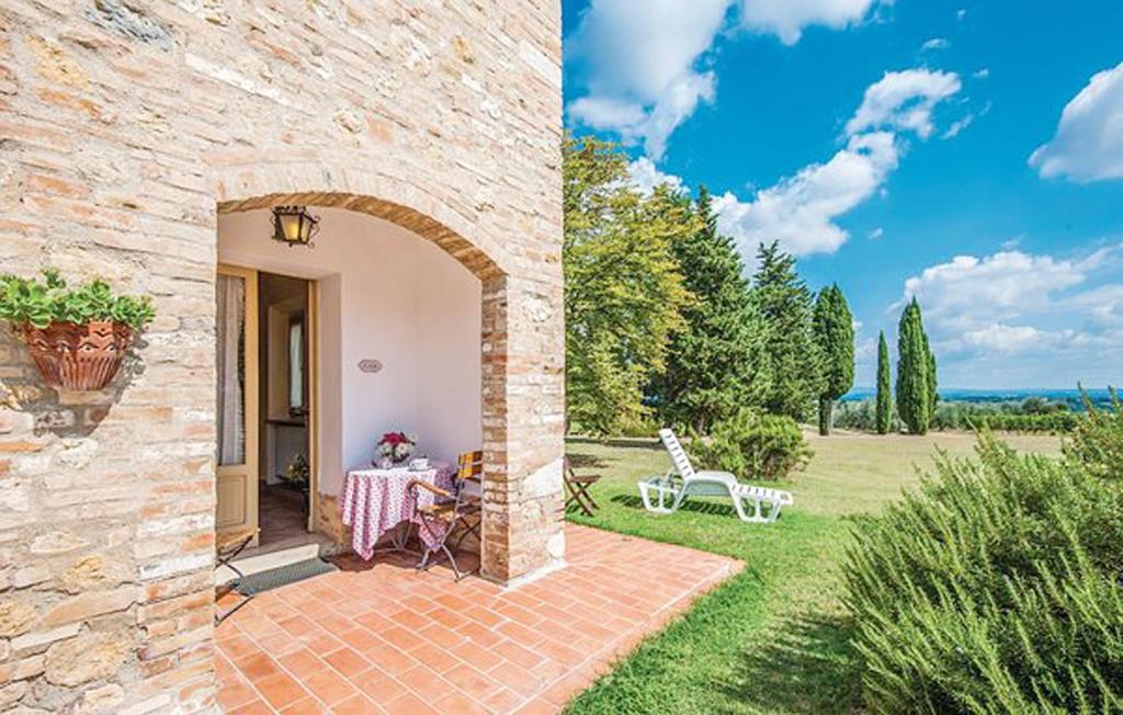 Cette maison en pierre dispose d'une table et d'une terrasse. dans l'établissement Agriturismo Fattoria Il Piano - Appartamento Stalla - San Gimignano, à San Gimignano