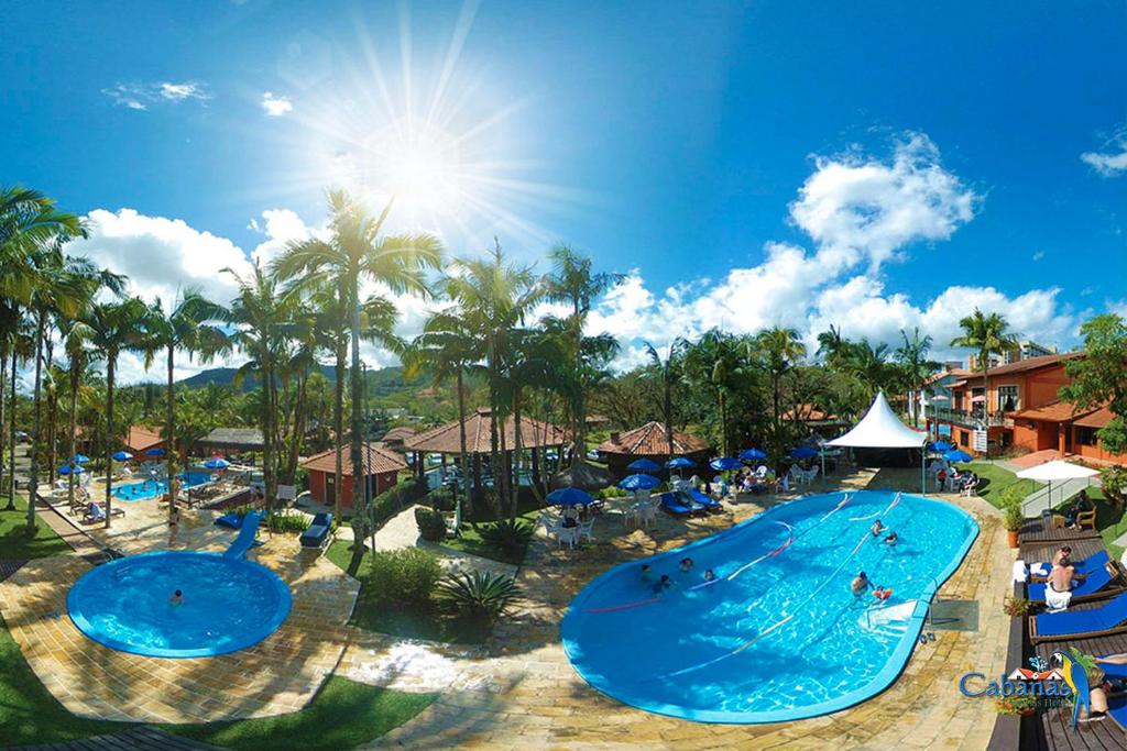 uma piscina num resort com pessoas a nadar nela em Cabanas Termas Hotel em Gravatal