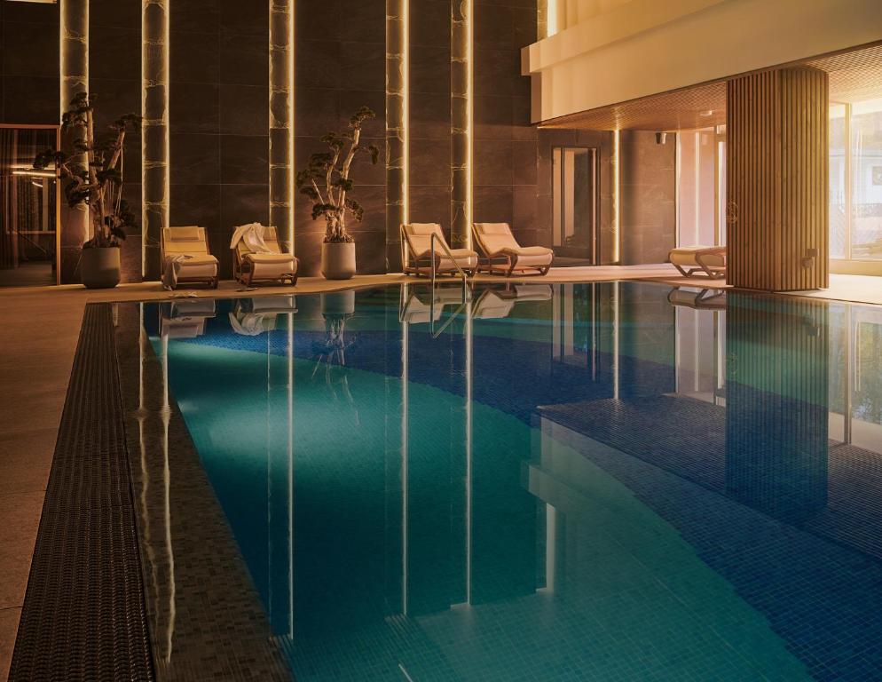 a swimming pool in a hotel with lounge chairs at SPA VILNIUS Druskininkai in Druskininkai