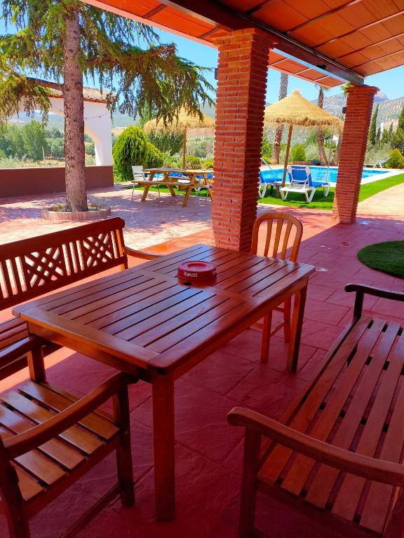 drewniany stół i 2 ławki na patio w obiekcie cortijo los arcos w Maladze