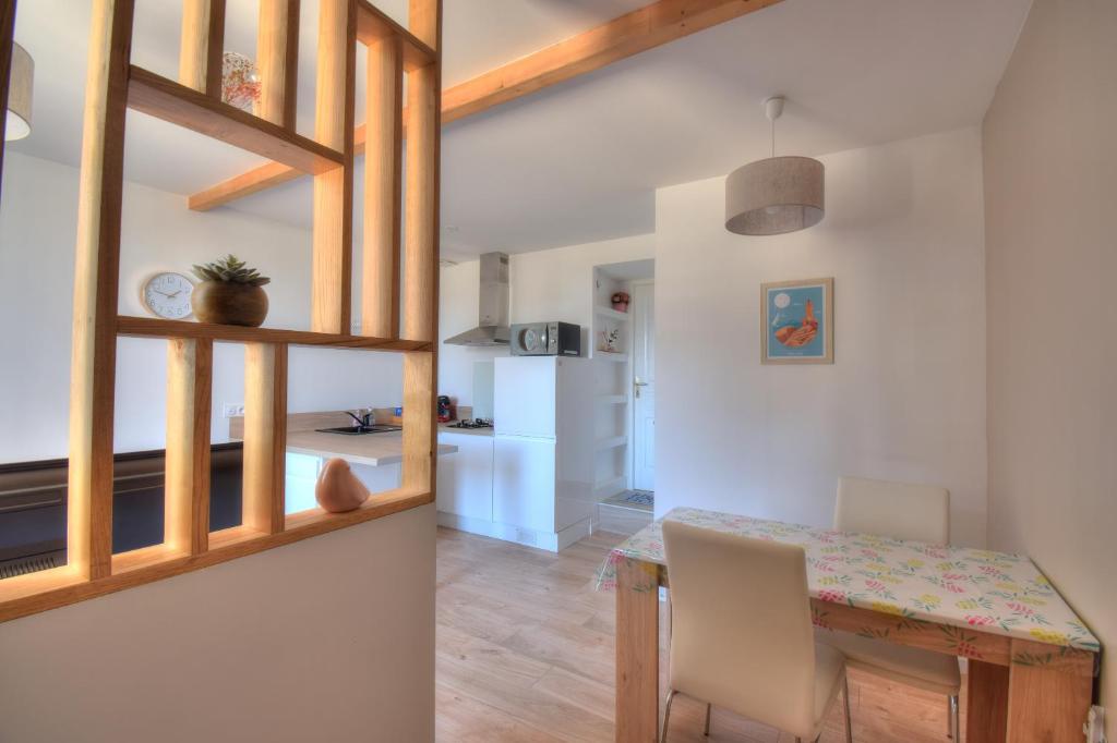 une cuisine et une salle à manger avec une table et des chaises dans l'établissement La vie en rose, à Ploubezre