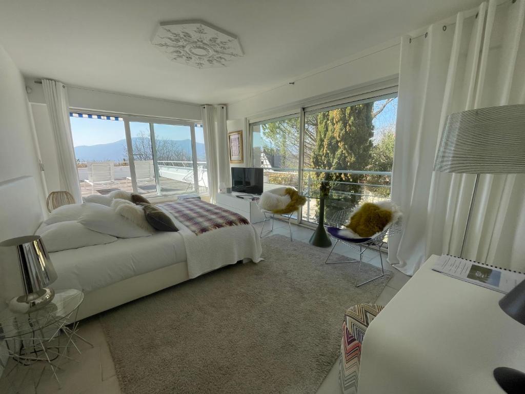 a bedroom with a bed and a large window at La Villa Haute Corniche in Obernai