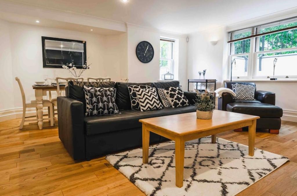 uma sala de estar com um sofá preto e uma mesa em Northum Place - Elegant City Centre Apartment em Leamington Spa