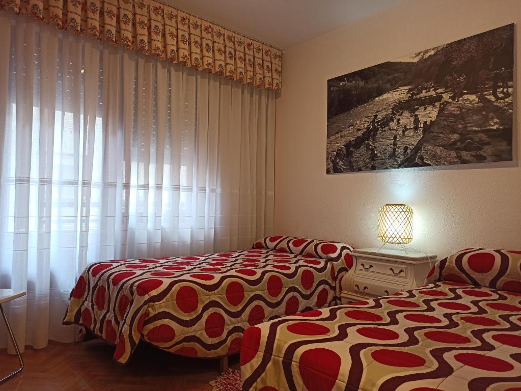 1 dormitorio con 2 camas y ventana en APARTAMENTO MARRODAN CENTRICO, en Arnedillo