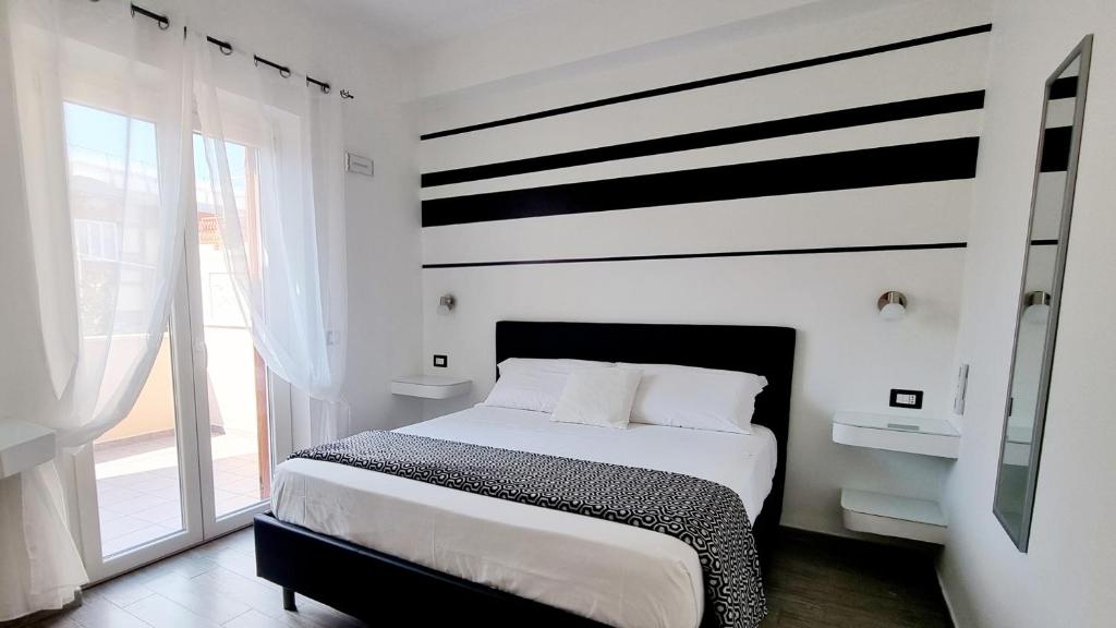 - une chambre dotée d'un lit avec un mur rayé noir et blanc dans l'établissement Residenza Magnolia, à Tropea
