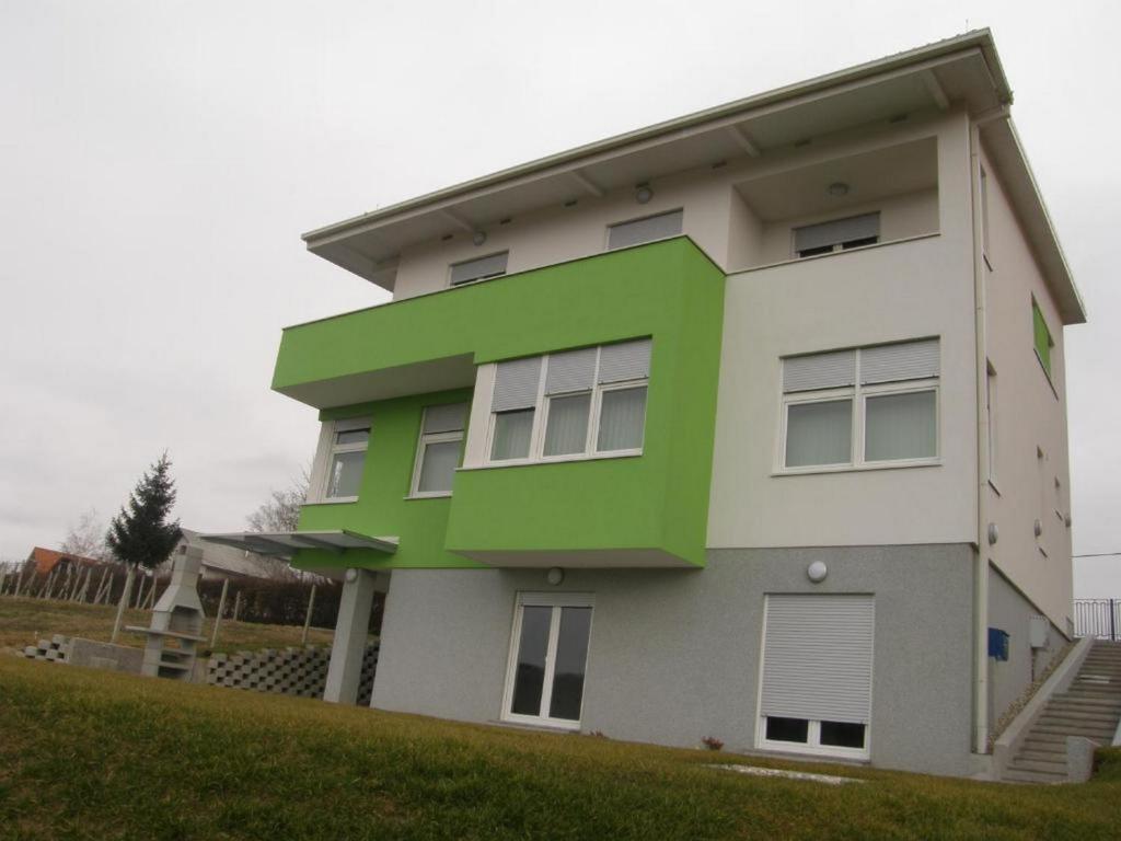 a green and white house with at Apartments Da - Dent in Sveti Ivan Zelina