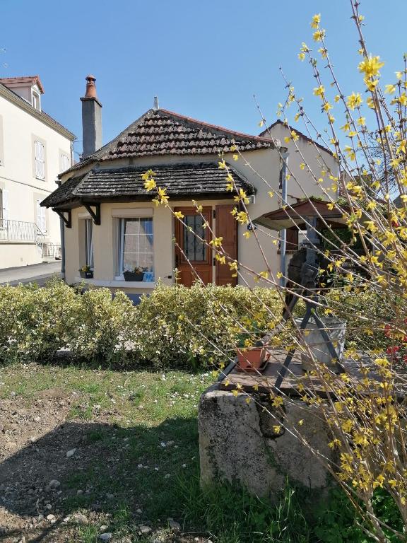 a small house with a window in a yard at Charmante maison prés de Vézelay in Voutenay-sur-Cure