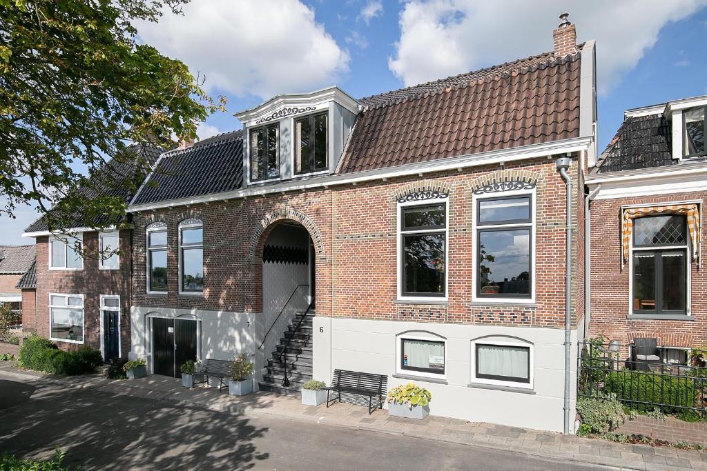 een rood bakstenen huis met een witte garage bij Molepôlle 6 - Stadslogementen Franeker in Franeker
