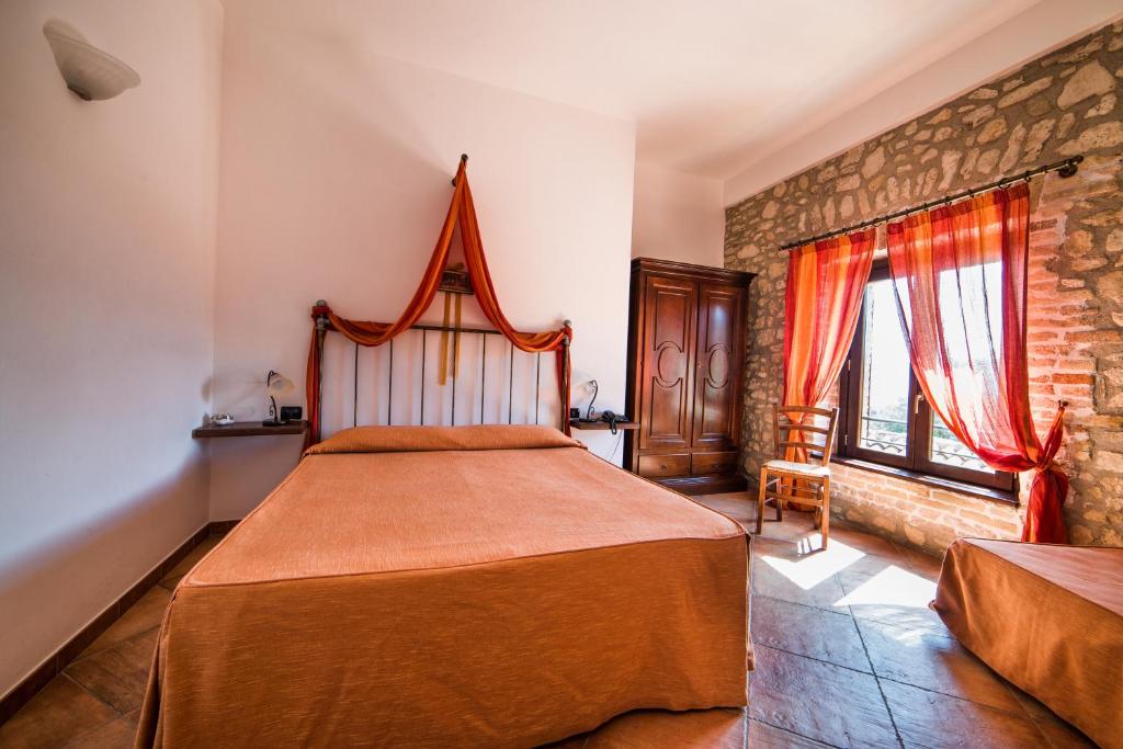 a bedroom with a large bed and a brick wall at Principe di Aragona in Aragona
