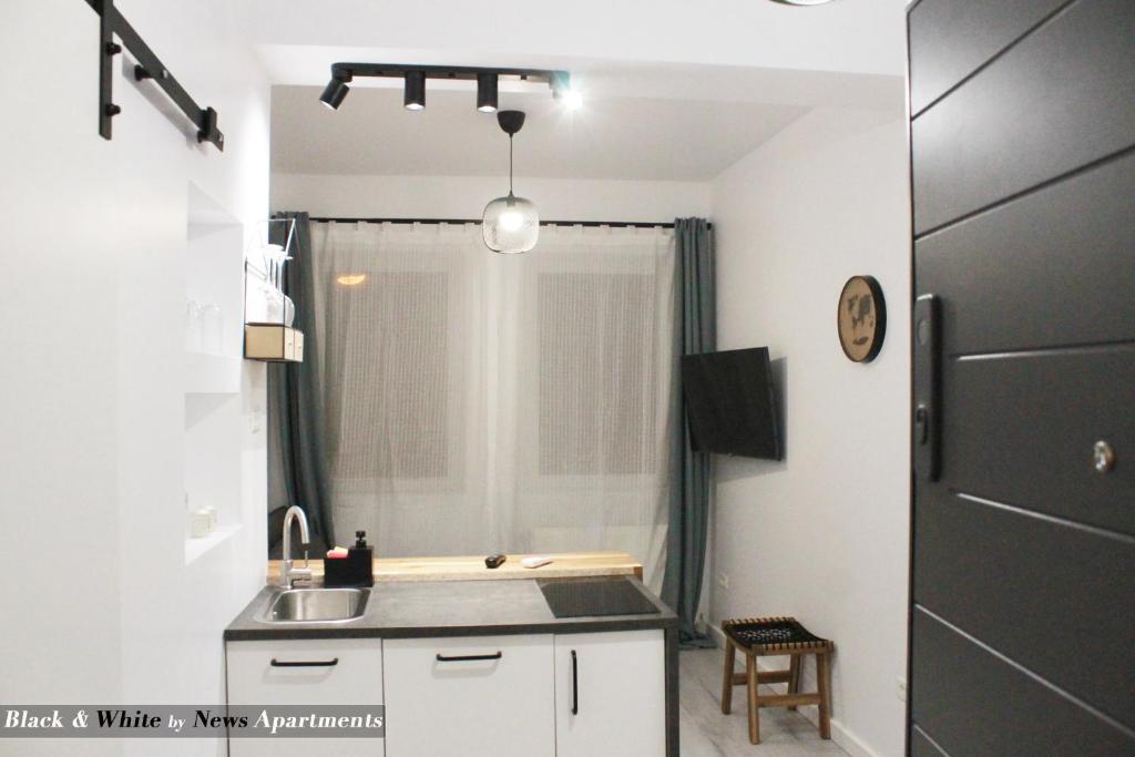 cocina con fregadero y encimera en Black & White - News Apartment, en Bucarest
