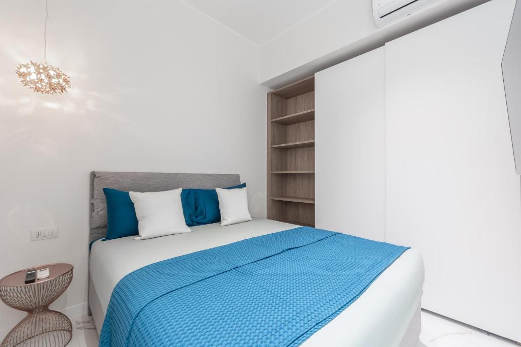 um quarto com uma cama com lençóis azuis e brancos em Milano Duomo cozy apartment em Milão