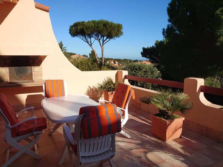patio con mesa y sillas en el balcón en 6AMB38 Villa avec terrasse dans résidence avec piscine commune en Collioure