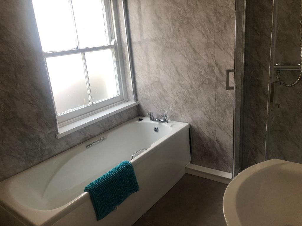a bathroom with a bath tub and a window at Wayfarer Inn in Instow