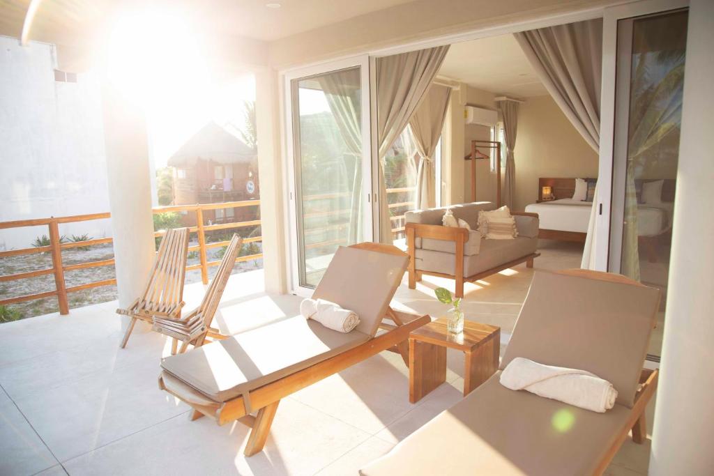 un soggiorno con 2 sedie e un divano di Noah Beach Hotel & Suites a Mahahual