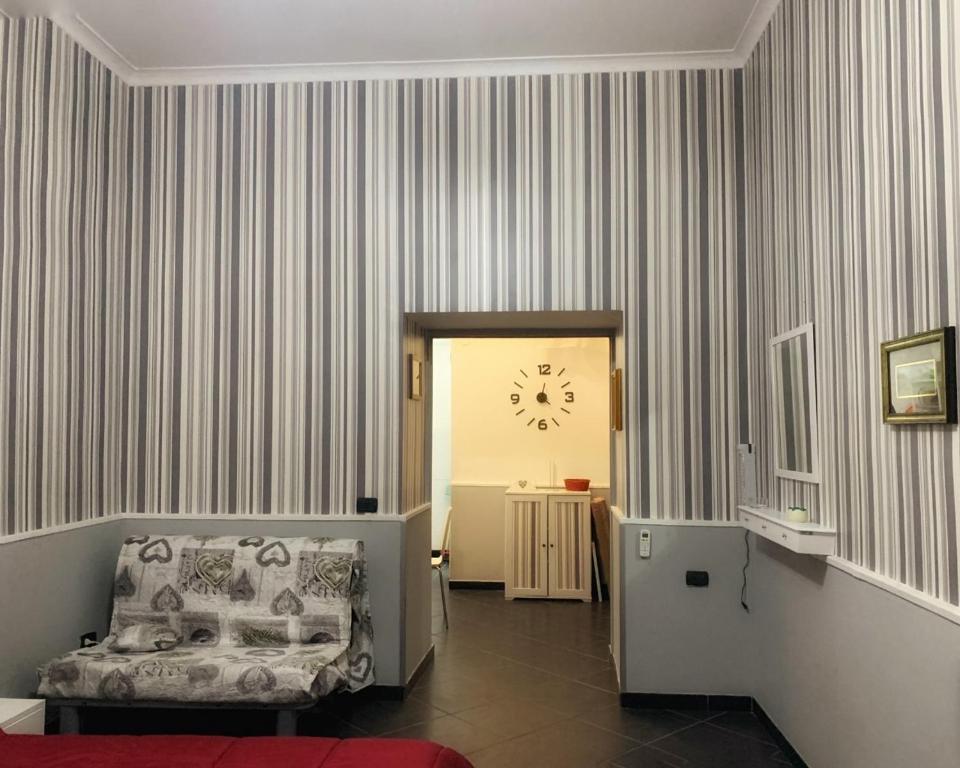 ナポリにあるTarsia Suiteの椅子と時計付きの部屋
