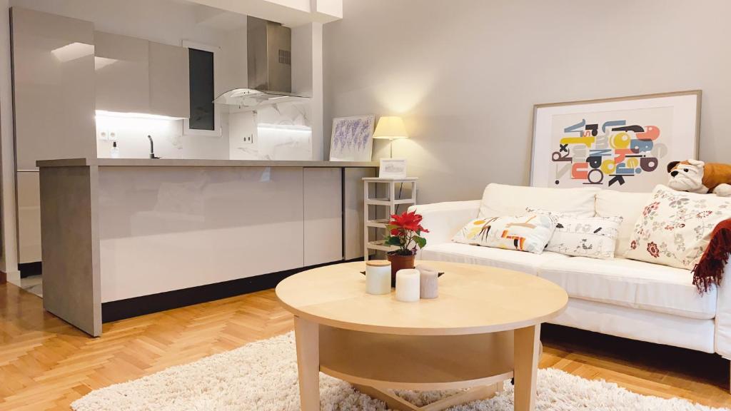 a living room with a white couch and a table at Cozy Newly Renovated 1 Bedroom Apartment in the heart of Athens in Athens