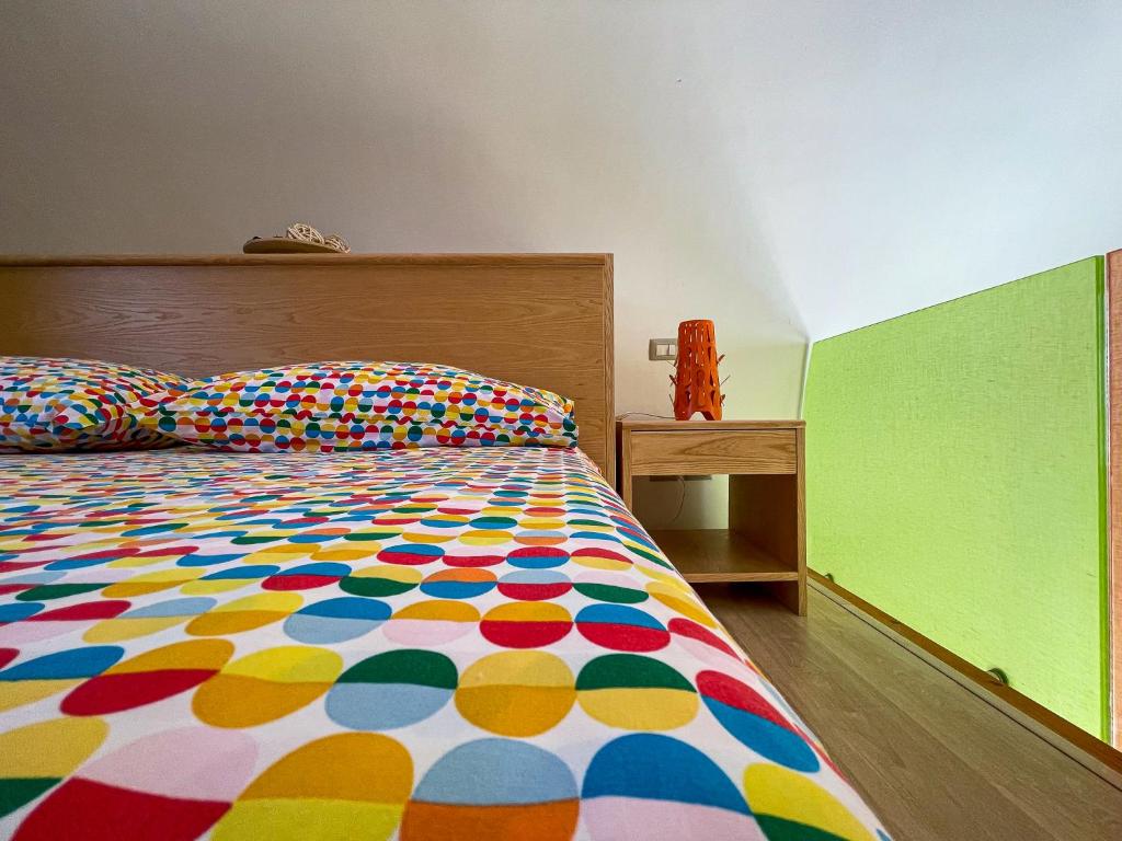 ein Schlafzimmer mit einem Bett mit einer bunten Bettdecke in der Unterkunft Hot Peppers Apartments in Sant'Agnello