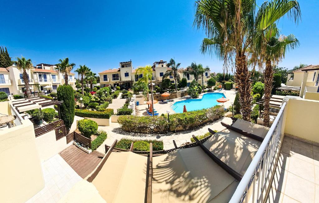 an aerial view of a resort with a pool and palm trees at Serena Townhouse in Peyia