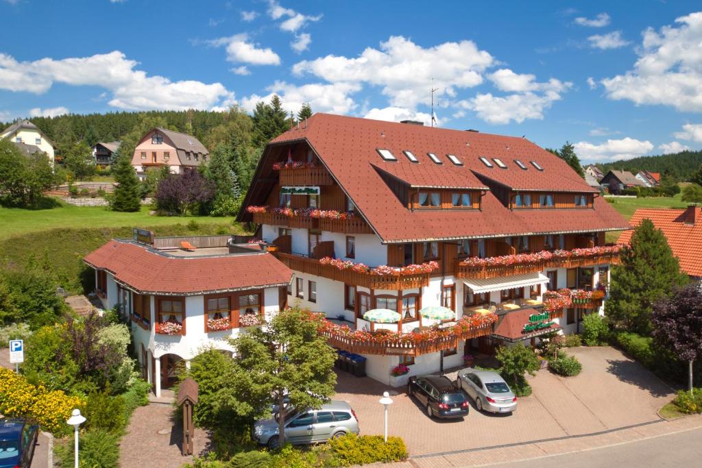 ein großes Haus mit rotem Dach in der Unterkunft Schreyers Hotel Restaurant Mutzel in Schluchsee