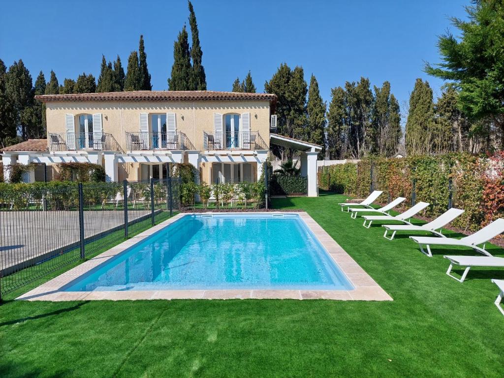 a villa with a swimming pool in front of a house at Le Clos de Saint Aygulf in Saint-Aygulf